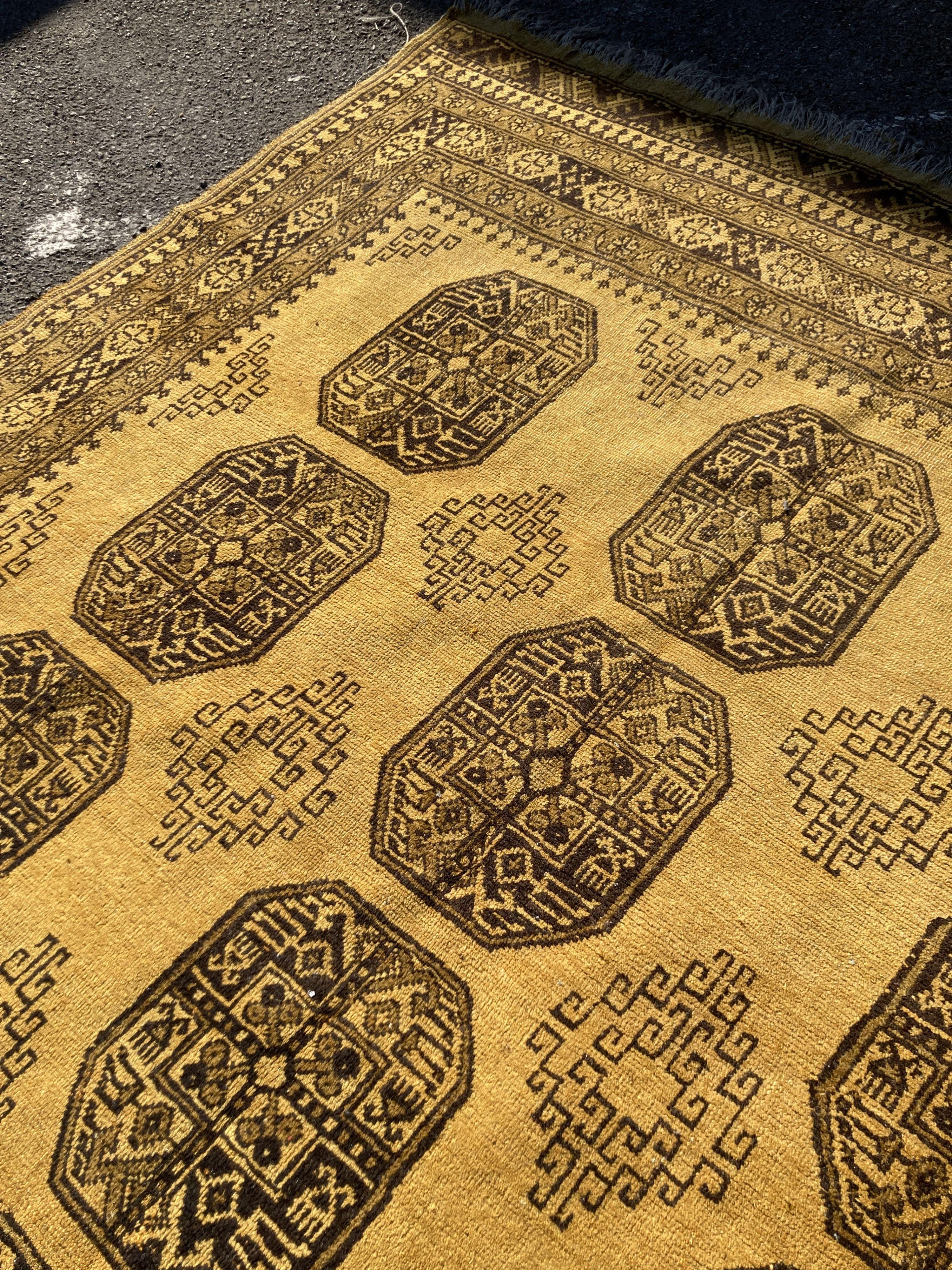 An Afghan gold ground carpet, 300 x 200cm